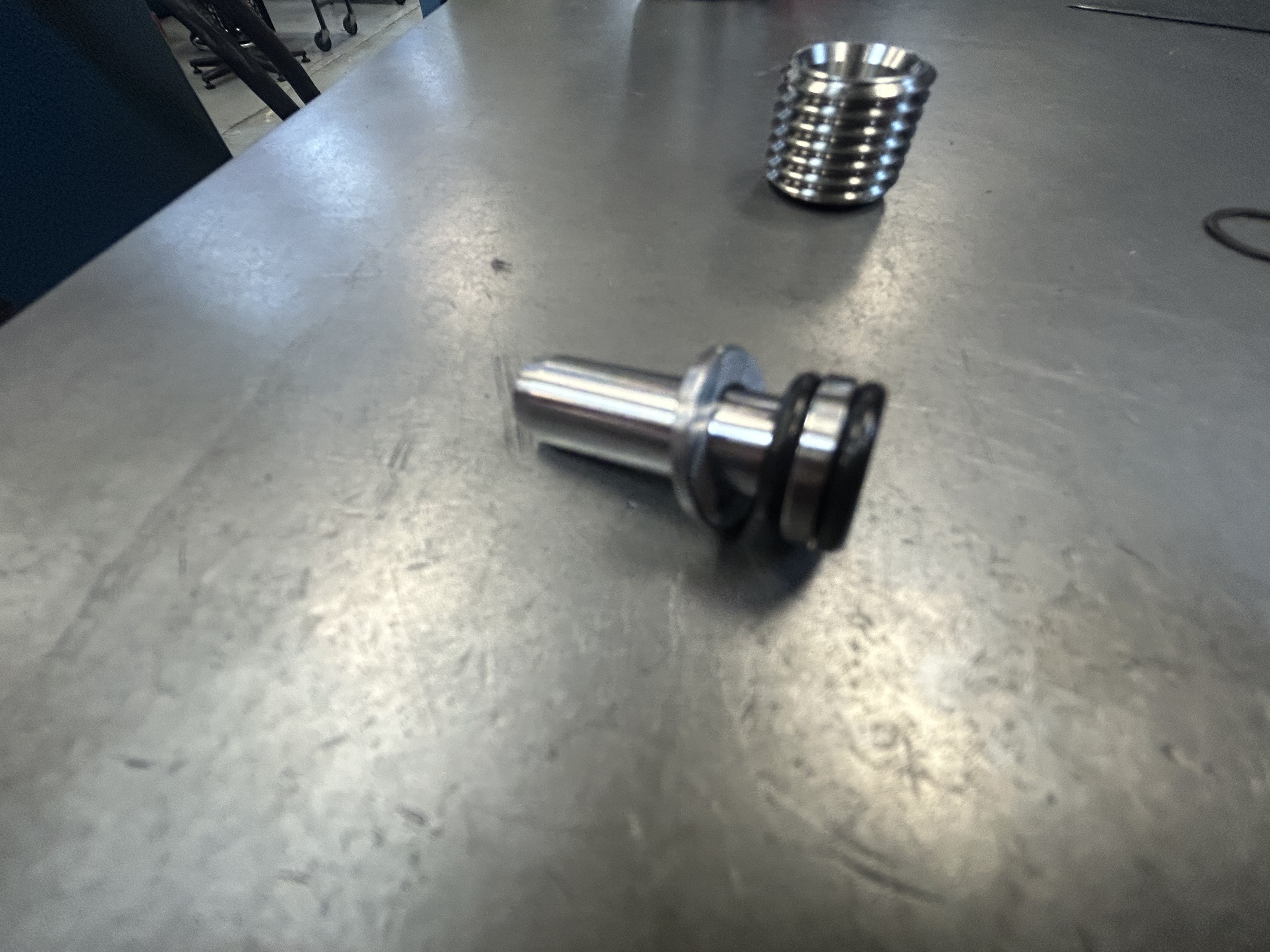 Assembled modular nozzle components together — threaded body, coolant tube, O-rings, washer, and retaining ring